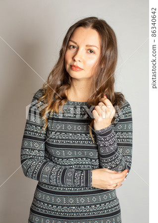 Young woman in warm dress isolated on light grey 86340642