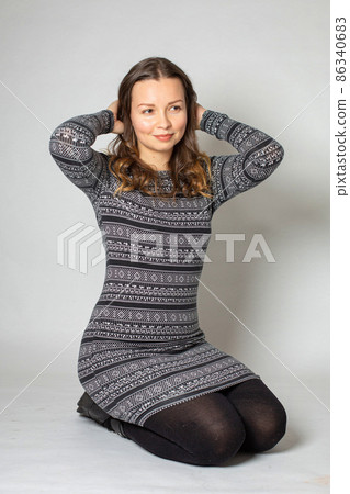 Young woman in warm dress isolated on light grey 86340683