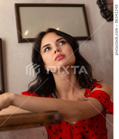 White dark haired woman with pictures behind White dark haired woman with pictures behind 86341248