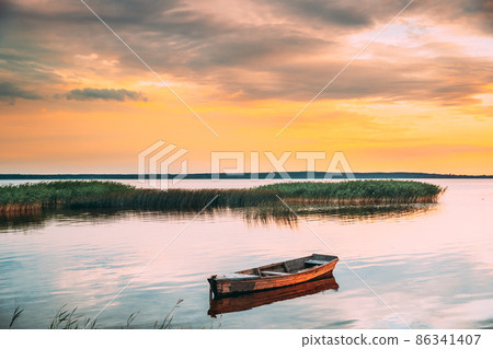 Braslaw Or Braslau, Vitebsk Voblast, Belarus. Wooden Rowing Fishing Boat In Beautiful Summer Sunset On The Dryvyaty Lake. This Is The Largest Lake Of Braslav Lakes. Typical Nature Of Belarus.Braslaw Braslaw Or Braslau, Vitebsk Voblast, Belarus. Wooden Rowing Fishing Boat In Beautiful Summer Sunset On The Dryvyaty Lake. This Is The Largest Lake Of Braslav Lakes. Typical Nature Of Belarus.Braslaw 86341407