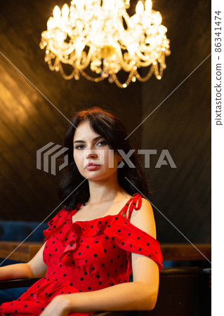 White dark haired woman in dark room White dark haired woman in dark room 86341474