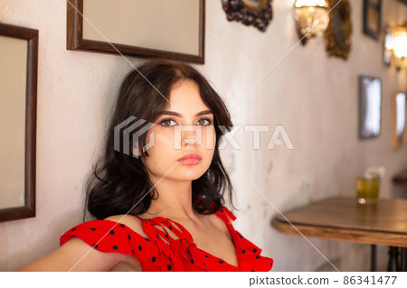 White dark haired woman with pictures behind 86341477
