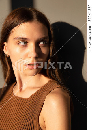Woman with dark hair on beige Woman with dark hair on beige 86341825