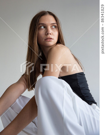 Woman with dark hair on dark grey Woman with dark hair on dark grey 86341829