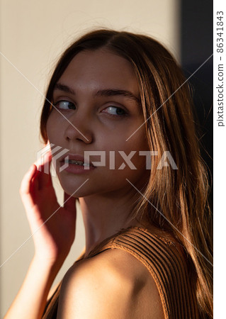 Woman with dark hair on beige Woman with dark hair on beige 86341843