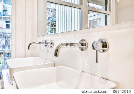 Charming bathroom with two sinks and a huge mirror Charming bathroom with two sinks and a huge mirror 86342019