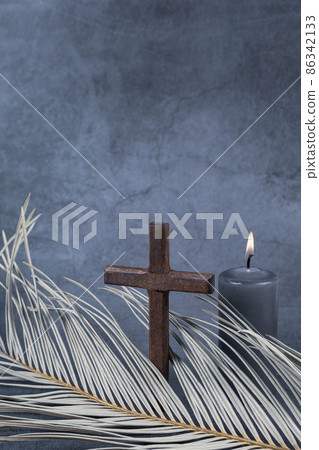 Catholic Cross with palm leaf and burning candle. Ash Wednesday, Lent season, Holy Week, Good Friday and Palm Sunday concept. Catholic Cross with palm leaf and burning candle. Ash Wednesday, Lent season, Holy Week, Good Friday and Palm Sunday concept. 86342133