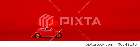 Small red car with two red hearts.  86342139