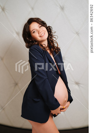 a cheerful pregnant woman in a black jacket with bare breasts and a belly a cheerful pregnant woman in a black jacket with bare breasts and a belly 86342692