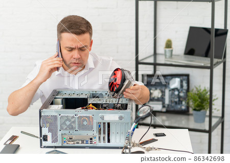 man calls repairman on phone, tries to fix computer himself and install cooler. man calls repairman on phone, tries to fix computer himself and install cooler. 86342698