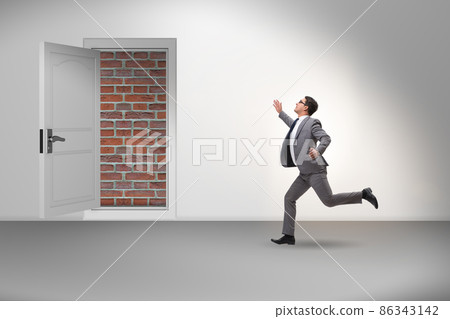 Businessman facing no exit with brick door Businessman facing no exit with brick door 86343142