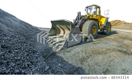 Wheel loader beside a pile of crushed gravel isolated on white background. 86343314