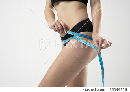 The girl taking measurements of her body on white background. 86344526