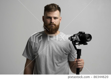 Professional videographer using dslr camera on gimbal stabilizer isolated on white background. Professional videographer using dslr camera on gimbal stabilizer isolated on white background. 86344620