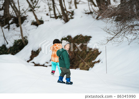 父母和孩子在雪地裡玩耍 父母和孩子在雪地裡玩耍 86345990