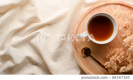 Cozy minimal tea table with dried flowers and teacup on wooden tray Cozy minimal tea table with dried flowers and teacup on wooden tray 86347385