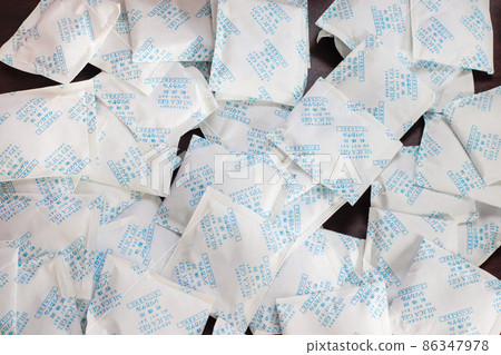 Desiccant gel bag on hand with Silica backgrounds 86347978
