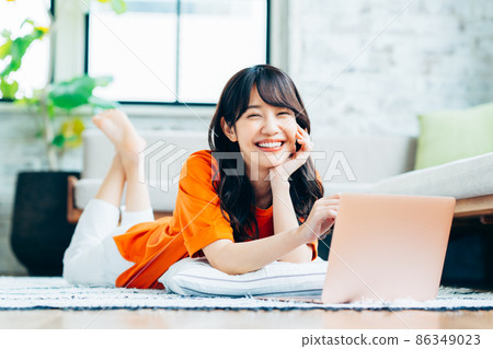 A young woman looking at a computer in the living room A young woman looking at a computer in the living room 86349023