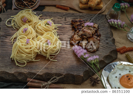 Spaghetti with Roasted Chicken with Black Pepper on a wooden plate Served with Fried Egg and Crispy butter toast. 86351100