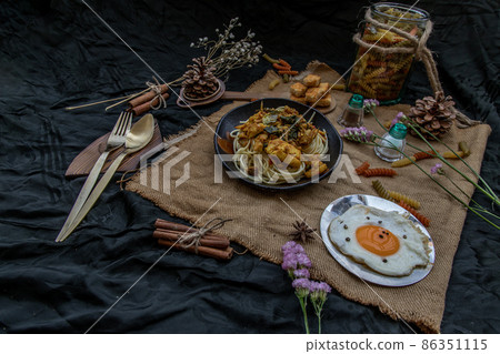 Spaghetti topped with Stir fried spicy snapper on a brown plate Served with Fried Egg and Crispy butter toast. Spaghetti topped with Stir fried spicy snapper on a brown plate Served with Fried Egg and Crispy butter toast. 86351115
