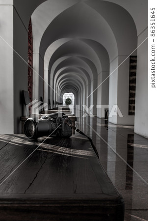 Natural light passing through the wall to the camera placed on a wooden table within Loha Prasart Metal Palace at Ratchanaddaram temple.. 86351645