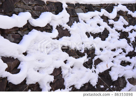 The stone wall of the passage to the main castle of Arato Castle and the snow on the stone wall 86353898