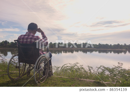 Young disabled man with blue sky background Young disabled man with blue sky background 86354139