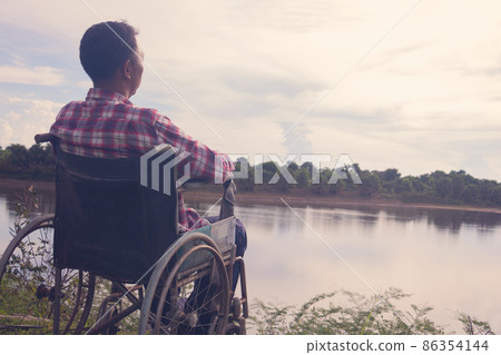 Young disabled man with blue sky background Young disabled man with blue sky background 86354144