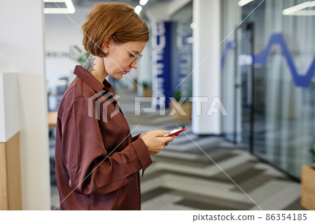 Tattooed Woman using Smartphone in Office 86354185