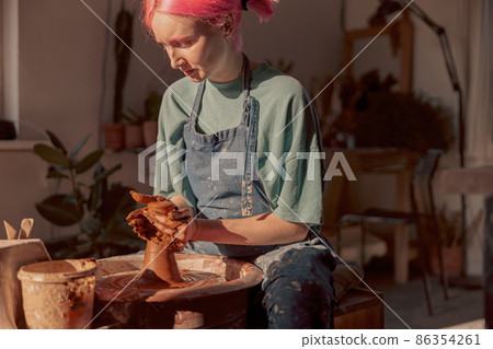 Potter working manually on pottery wheel in workroom 86354261