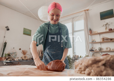 Young master molding clay product in ceramics workshop 86354286