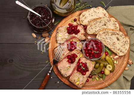 Sliced Traditional French terrine covered with bacon on dark wooden background Sliced Traditional French terrine covered with bacon on dark wooden background 86355556
