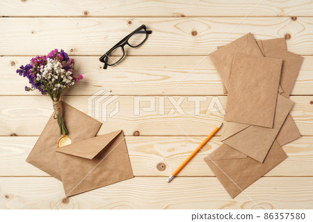 Flowers, blank paper and envelope on a table top Flowers, blank paper and envelope on a table top 86357580