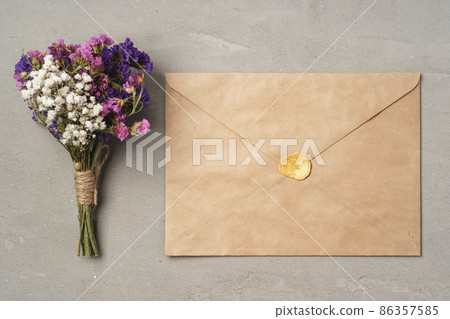 Top view of flower bouquet and craft envelope on gray surface flat lay Top view of flower bouquet and craft envelope on gray surface flat lay 86357585