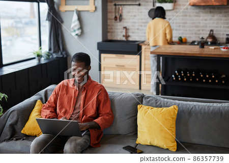 Man using Laptop on Couch Man using Laptop on Couch 86357739
