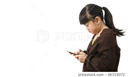 Asian Child is watching the phone on the  white background, using a mobile phone for a long time hurts her eyes and has an aggressive atmosphere. Concept danger for children's mobile phones concept. 86358072