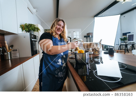 Cooking - Woman in modern kitchen, preparing spaghetti 86358163