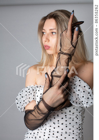 Woman with blonde hair on dark grey Woman with blonde hair on dark grey 86358262