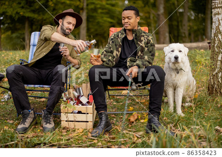Two male friends fishing with alcoholic drinks 86358423