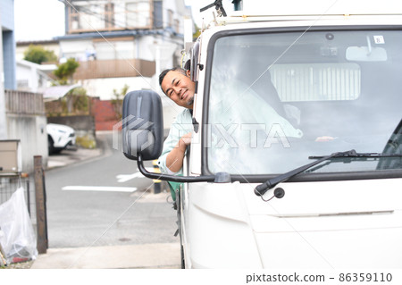 Middle man in work clothes driving a truck 86359110