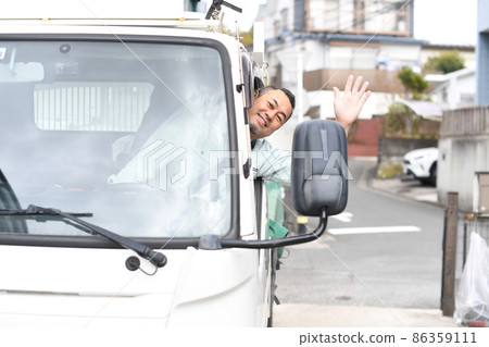 Middle man in work clothes driving a truck Middle man in work clothes driving a truck 86359111