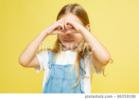 White european baby girl isolated on yellow White european baby girl isolated on yellow 86359190