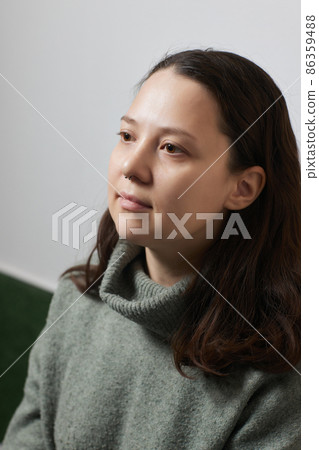 Closeup of a young woman's visage with piercing septum hanging from her nose. Closeup of a young woman's visage with piercing septum hanging from her nose. 86359488