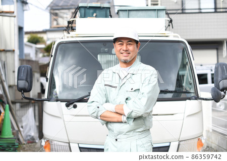 Middle man in work clothes with arms folded in front of the truck Middle man in work clothes with arms folded in front of the truck 86359742