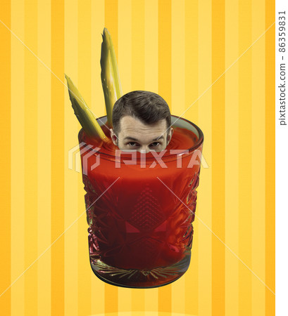 Young man's head peeking out of glass with bloody mary cocktail isolated on light yellow background. Pop art, retro style. Concept of drinks, taste, party. Young man's head peeking out of glass with bloody mary cocktail isolated on light yellow background. Pop art, retro style. Concept of drinks, taste, party. 86359831