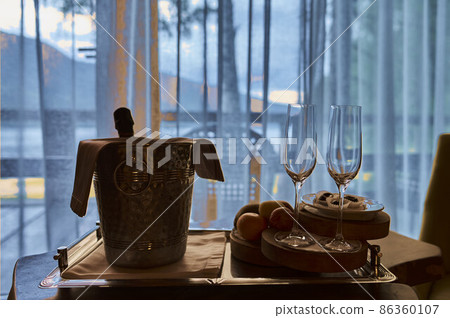 two vine glasses standing on black tray against window. 86360107