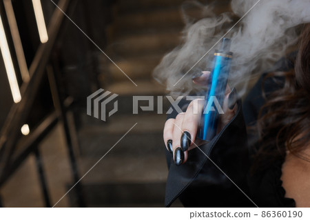 disposable electronic cigarettes in hand. The concept of modern smoking, vaping and nicotine. disposable electronic cigarettes in hand. The concept of modern smoking, vaping and nicotine. 86360190