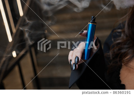 disposable electronic cigarettes in hand. The concept of modern smoking, vaping and nicotine. disposable electronic cigarettes in hand. The concept of modern smoking, vaping and nicotine. 86360191