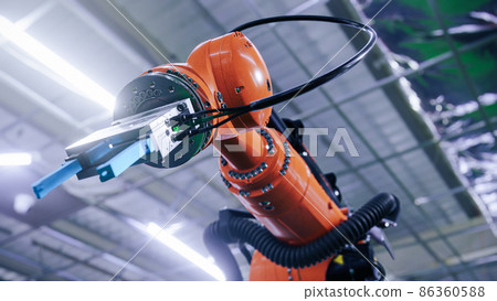 Industrial robot arm manipulating the assembly at the modern factory. Low angle shot 86360588