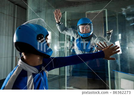A man trains a woman as an astronaut. Classes on flying in a wind tunnel. A man trains a woman as an astronaut. Classes on flying in a wind tunnel. 86362273